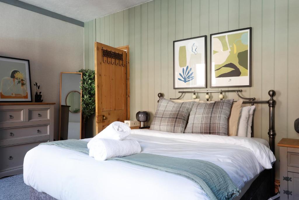 a bedroom with a large bed with towels on it at Ashley Suite - Cozy 1BR Maisonette with Parking & WIFI in Barry