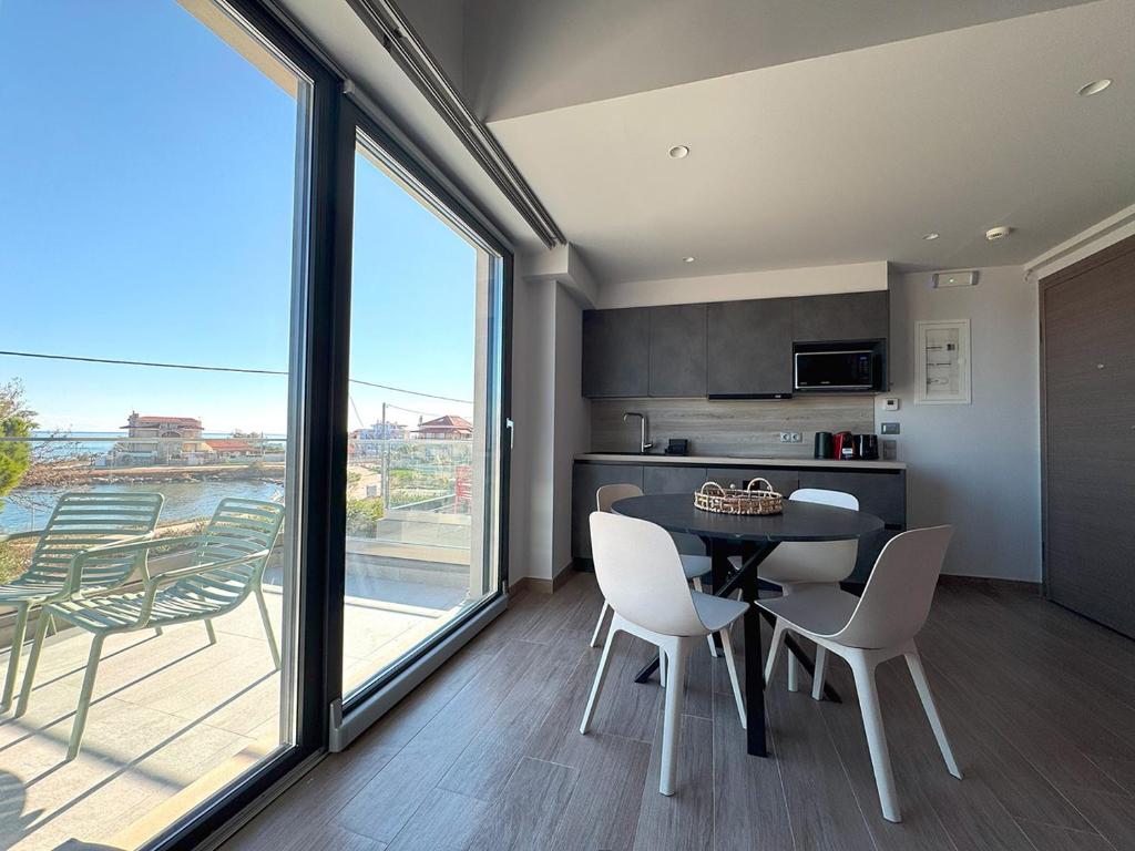 a kitchen and dining room with a table and chairs at Artemis Blue in Artemida