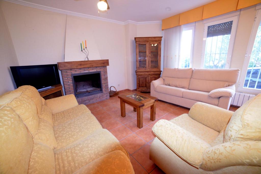a living room with two couches and a fireplace at Casas Rurales el Jardín in Jorquera