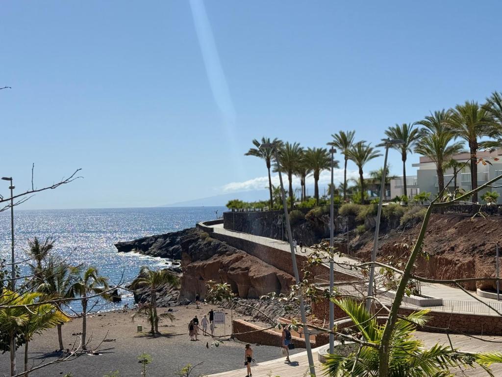 people walking on a beach with palm trees and the ocean at CasaMaria in Playa Paraiso