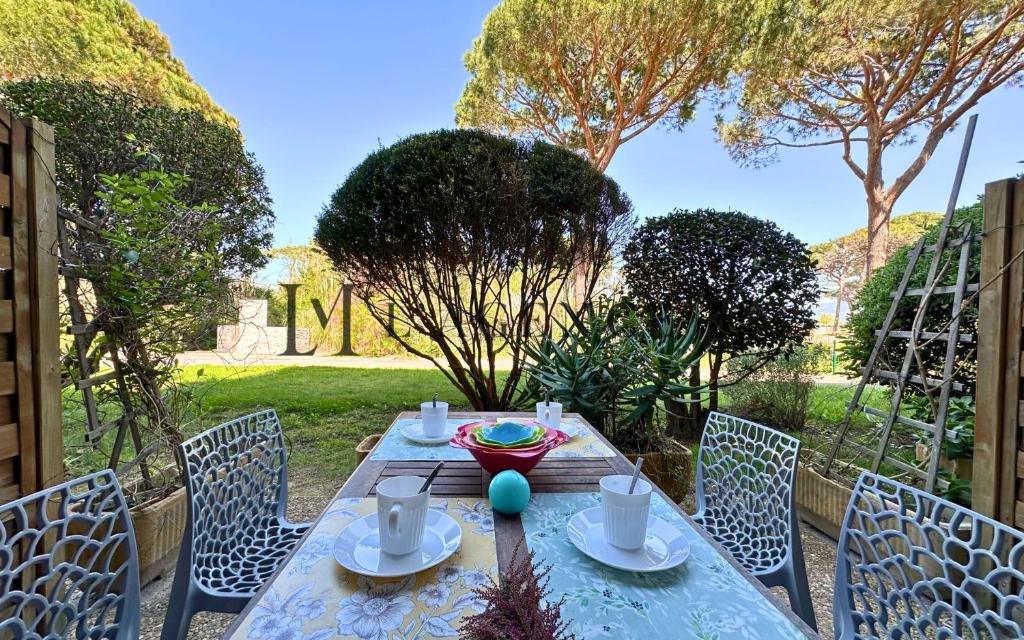 une table en bois avec des chaises et une tableastery ... dans l'établissement Studio Pinea Les pieds dans l'eau CALVI, à Calvi