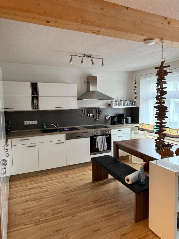 cocina con armarios blancos y suelo de madera en Ferienwohnung in Thale, en Thale