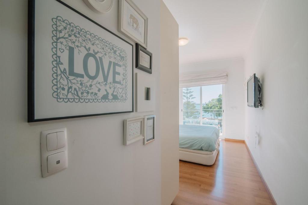 Zimmer mit einem Bett und einem Bild von Liebe an der Wand in der Unterkunft Casa da Rita in Olhão