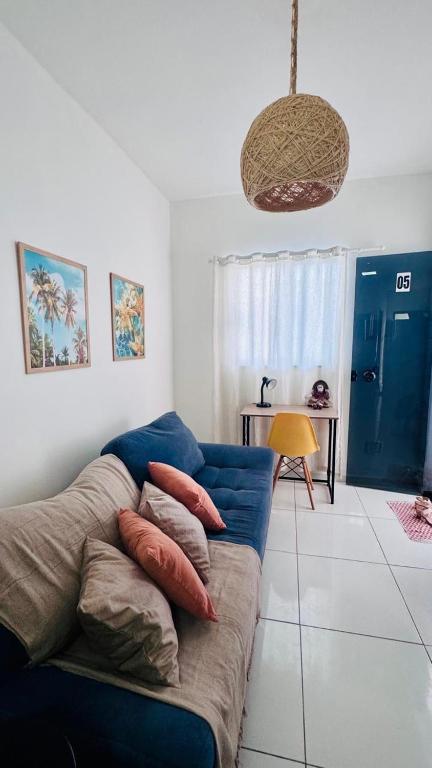 a living room with a blue couch with pillows on it at Ap5- atrás da Passarela do Caranguejo Atalaia - térreo - 2 ar cond in Aracaju