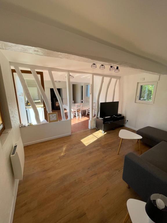 a living room with a couch and a tv at Maison à la campagne in Auvilliers