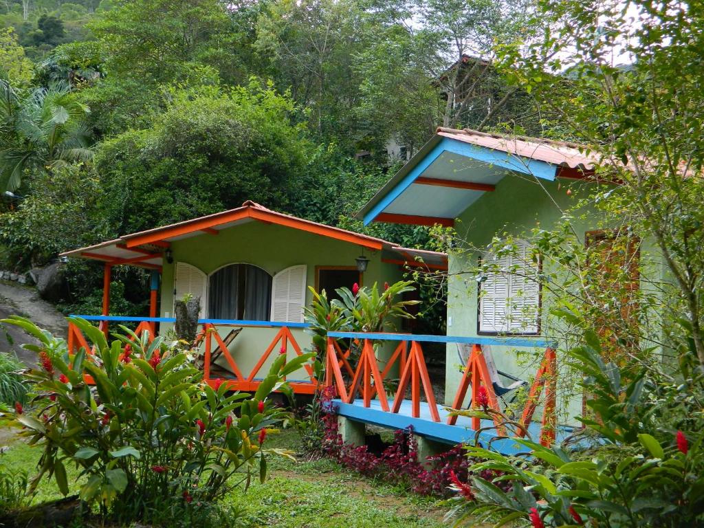 een klein huis met een blauw en oranje hek bij Bicho do Mato Suites in Barreira