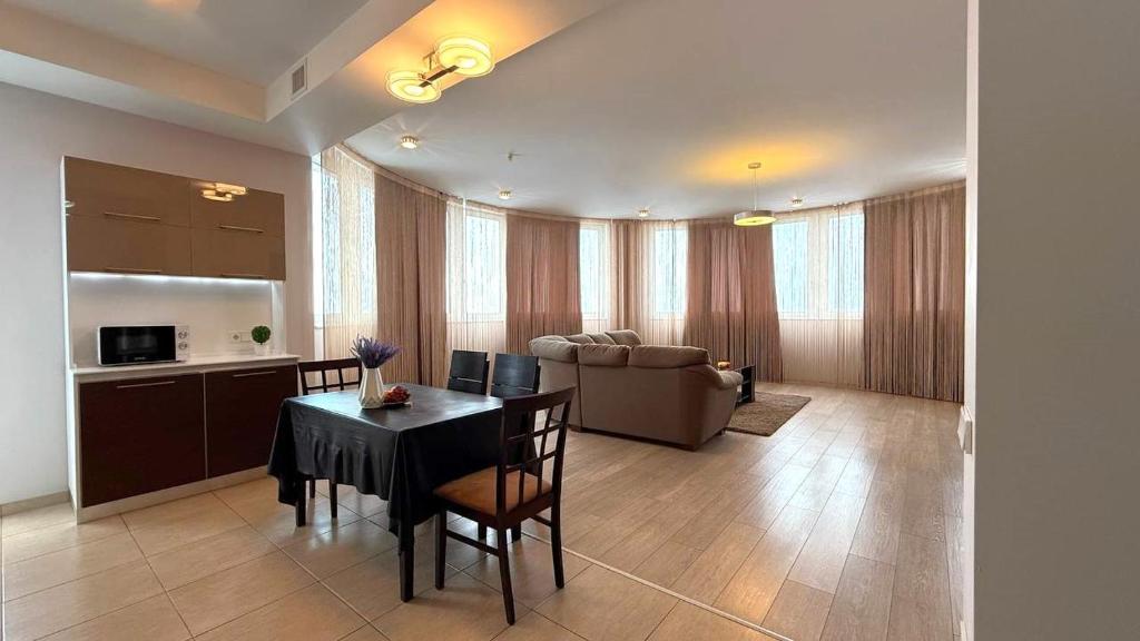 a kitchen and a dining room with a table and chairs at ClearView Apartment in Kharkiv