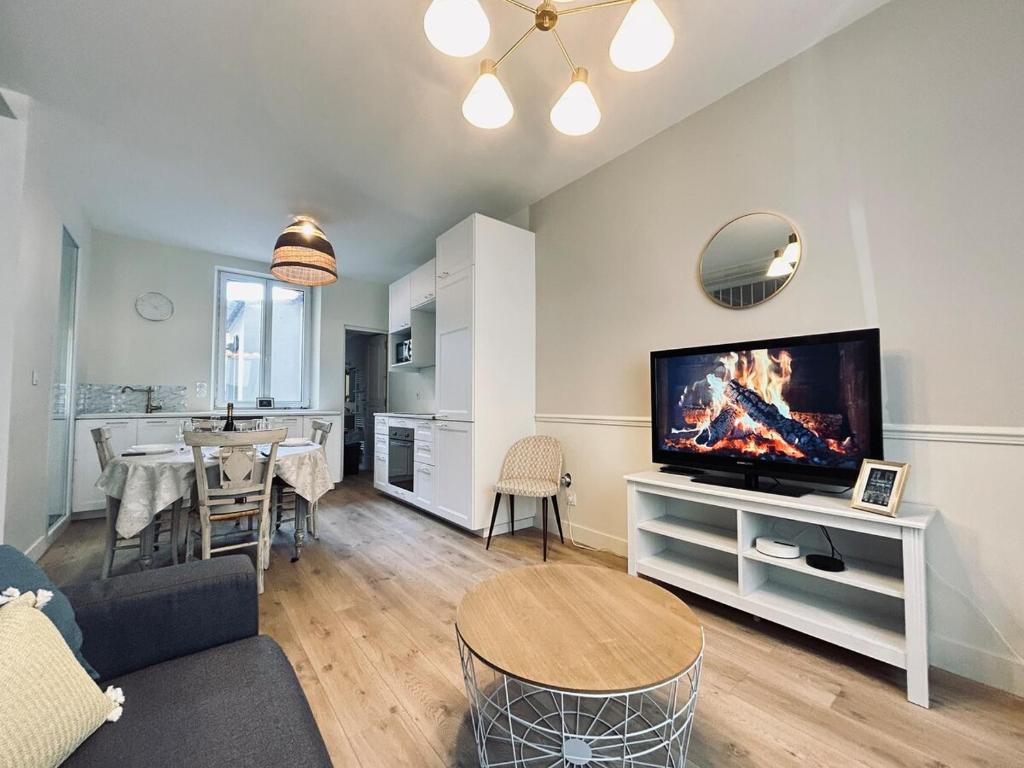 un salon avec une télévision et une salle à manger dans l'établissement Marzilly maison cosy 3 chbrs avec suite parentale, à Reims