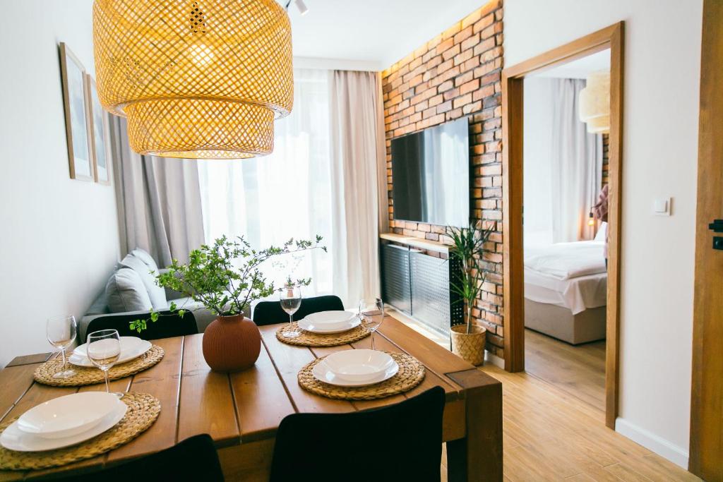 a dining room with a table with chairs and a room with a bed at Apartament Ulubiony Mariental Residence in Szklarska Poręba