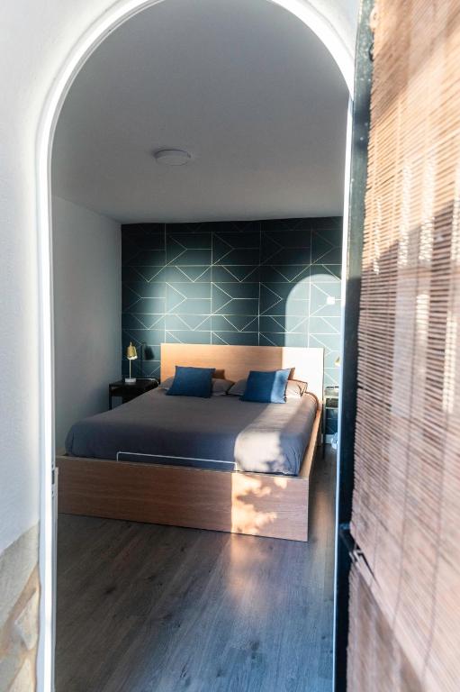 a bedroom with a bed with a blue wall at Suite 5 in Cala del Moral