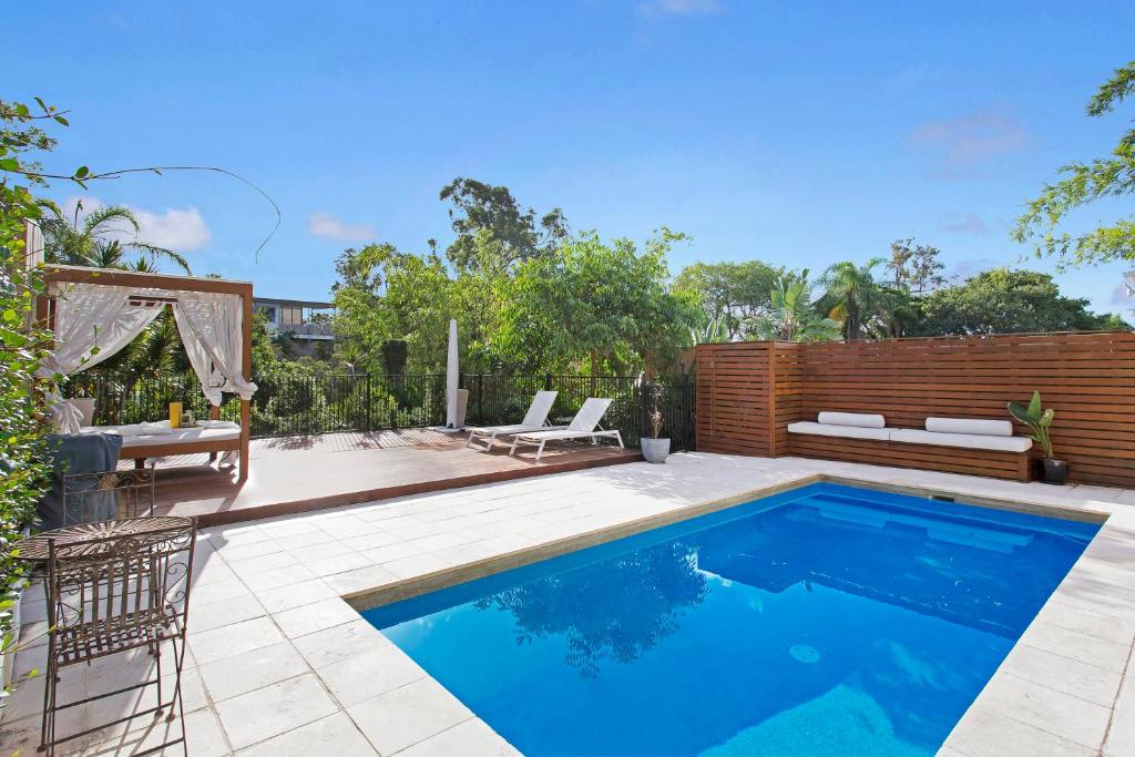 a swimming pool in a backyard with a wooden fence at Large Family Home with Pool & Spa in Brisbane