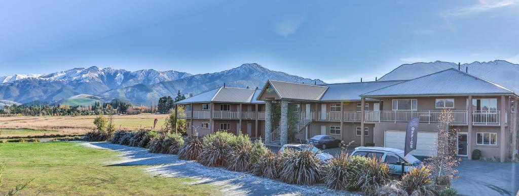 a large house with mountains in the background at Hanmer Springs Retreat in Hanmer Springs