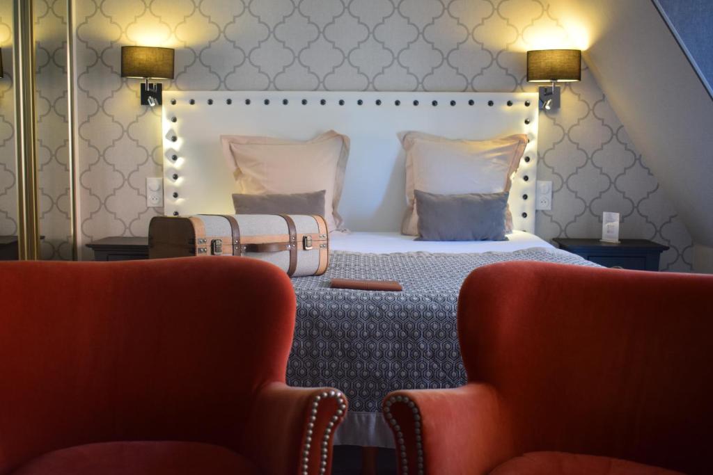 a hotel room with a bed with a suitcase at Le Trophée Boutique Hôtel Spa- La Loggia Appart'hôtel in Deauville