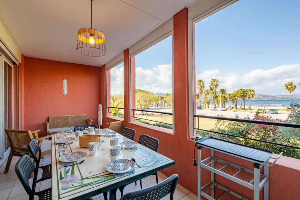 - une salle à manger avec une table et une vue sur la plage dans l'établissement Appartement La Perle Marine - Welkeys, à Cogolin