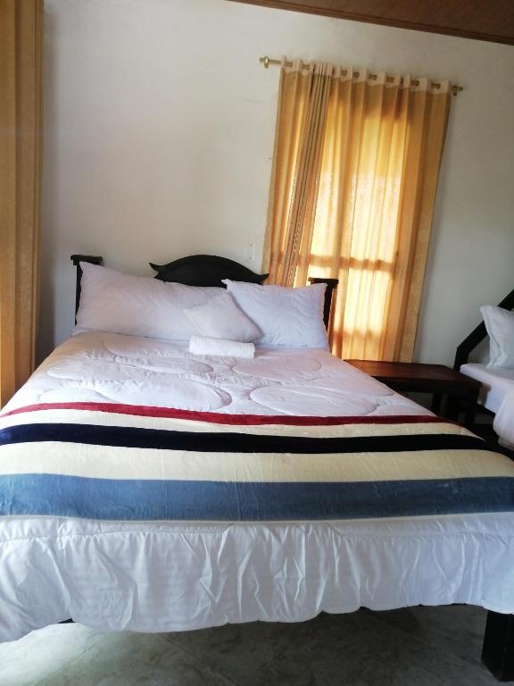 Rúm í herbergi á Curitagua Hotel Campestre