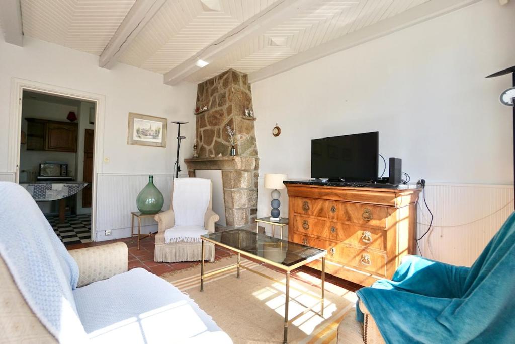un salon avec un canapé et une télévision dans l'établissement La maison de la rade - 200m de la plage, à Larmor-Plage