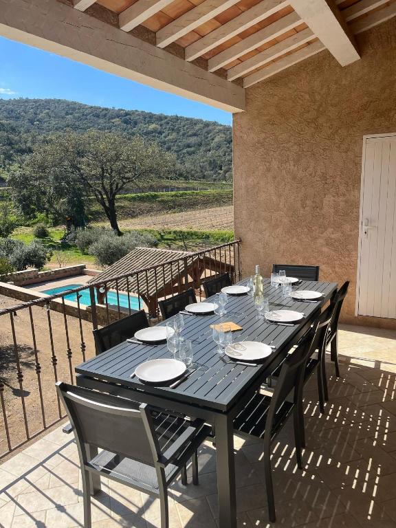 une table noire et des chaises sur une terrasse dans l'établissement Maison calme au cœur des vignes, à Cogolin