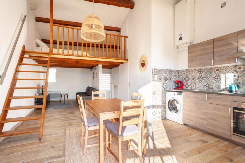 une cuisine et une salle à manger avec une table en bois et un escalier dans l'établissement Saint PonsCocon au pied du Panier avec balcon, à Marseille