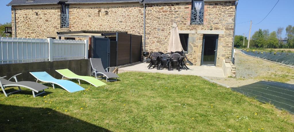 un groupe de chaises et de tables devant un bâtiment dans l'établissement So'Home, à Saint-Père
