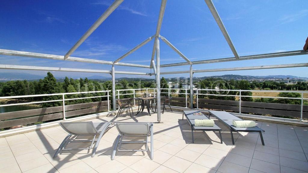 un patio avec des chaises et une table sur un toit dans l'établissement 3 bedroom penthouse apartment near cannes, à Mandelieu-la-Napoule