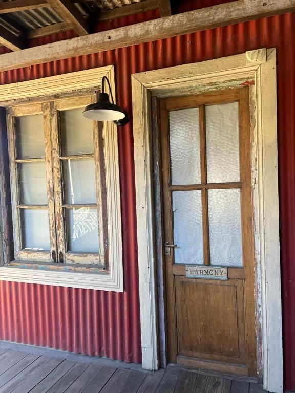 a room with two windows and a wooden door at mercado NL in Villa La Angostura
