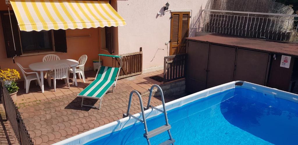 a house with a swimming pool and a patio with a table at Casa PO LAZISE in Lazise