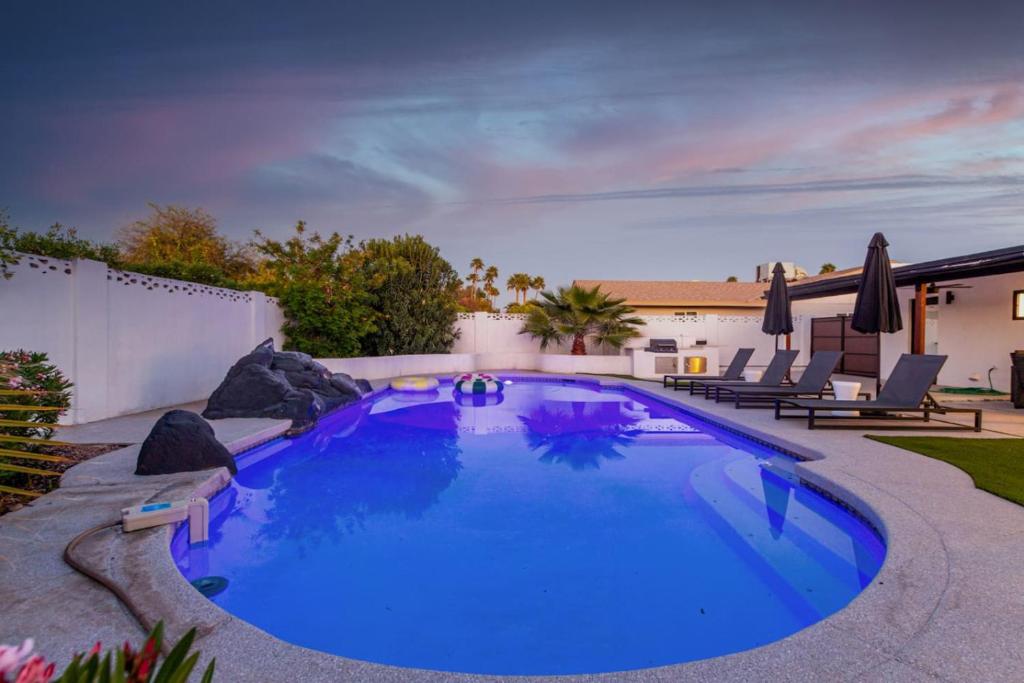 a large pool with blue water in a backyard at Luxury 4BR Retreat Heated Pool, Mini Golf and BBQ in Phoenix