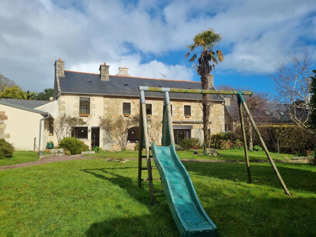 - une aire de jeux dans une cour en face d'une maison dans l'établissement Grande longère au port, à Perros-Guirec