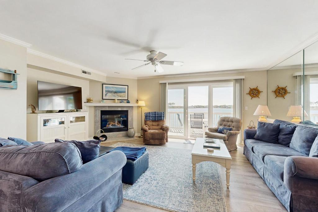 a living room with blue couches and a tv at Salt Pond - 15 Schooner Vill in Bethany Beach