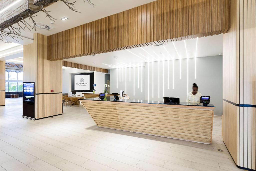 a man sitting at a counter in a lobby at Sonesta Maho Beach All Inclusive Resort Casino & Spa in Maho Reef