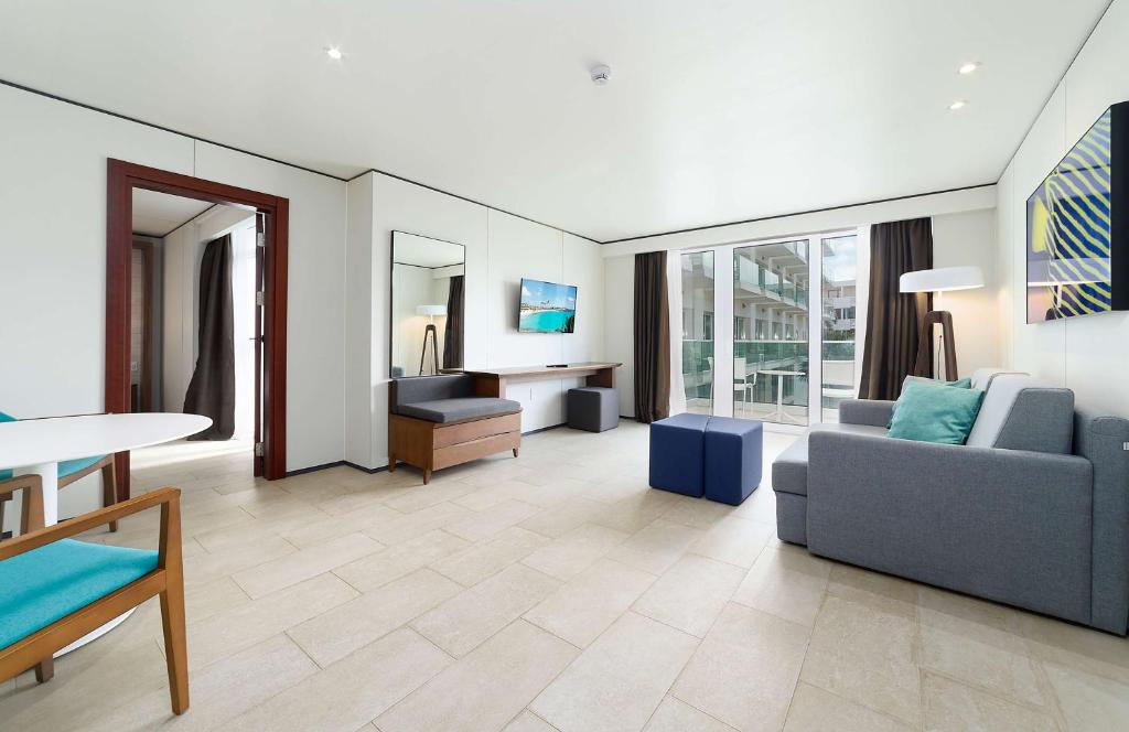 a living room with a couch and a table at Sonesta Maho Beach All Inclusive Resort Casino & Spa in Maho Reef