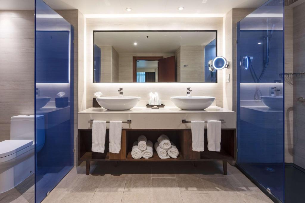 a bathroom with two sinks and a mirror at Sonesta Maho Beach All Inclusive Resort Casino & Spa in Maho Reef