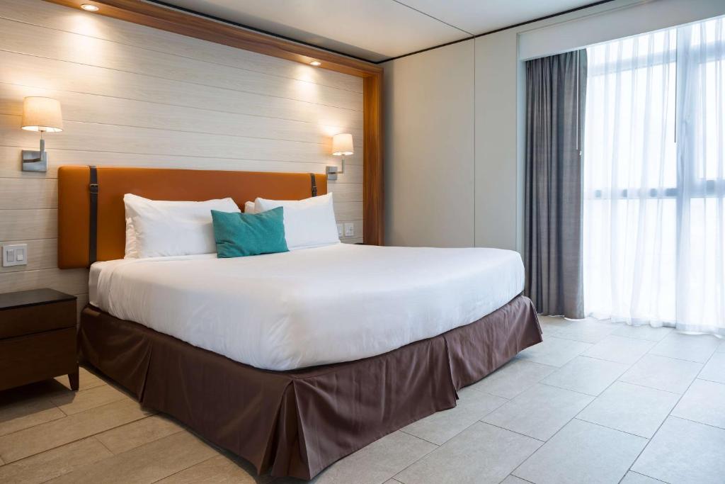 a large white bed in a hotel room at Sonesta Maho Beach All Inclusive Resort Casino & Spa in Maho Reef