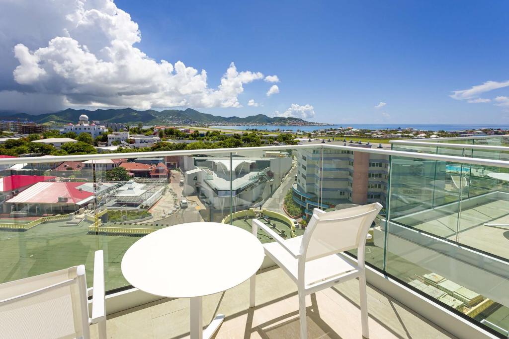 a balcony with a white table and two chairs at Sonesta Maho Beach All Inclusive Resort Casino & Spa in Maho Reef
