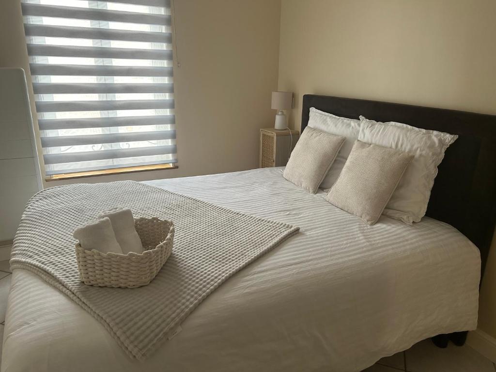 - une chambre avec un lit blanc et un panier dans l'établissement T2 rénové proche des arènes, à Saintes