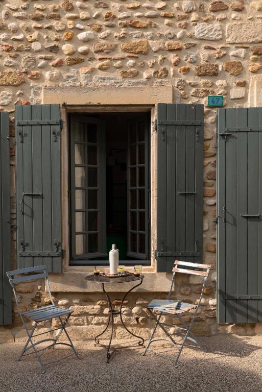 une table et deux chaises devant un bâtiment dans l'établissement la Perroya, à Visan