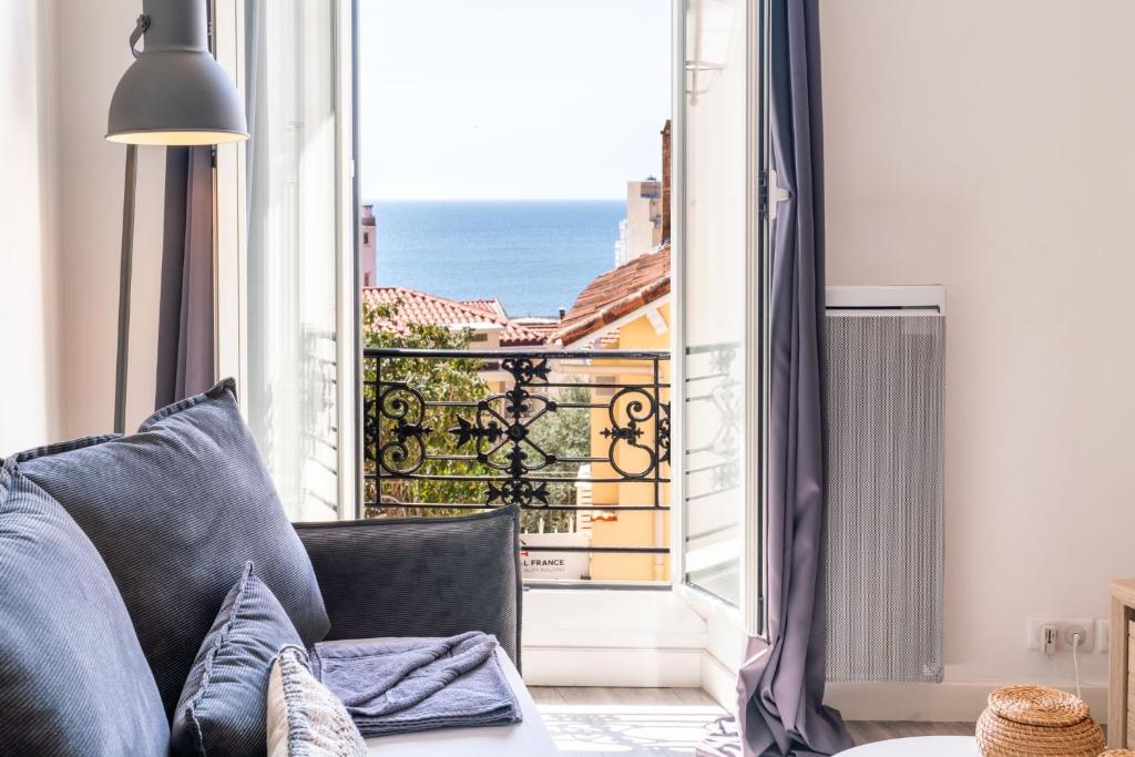 un salon avec un canapé et une vue sur l'océan dans l'établissement Le refuge du Suquet, quartier authentique de Cannes, vue mer, à Cannes