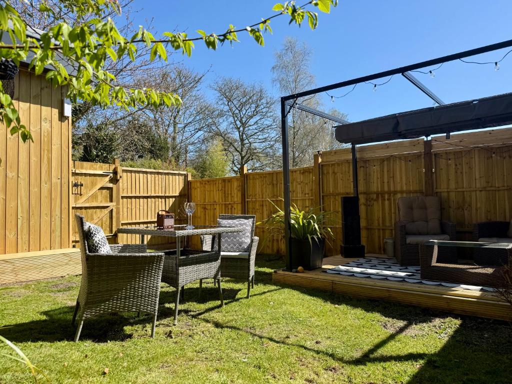 a patio with a table and chairs in a backyard at Acorn Lodge Pentewan in St Austell