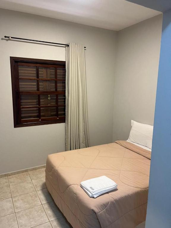 a bedroom with a bed with a towel on it at Pousada Apear in Andradas