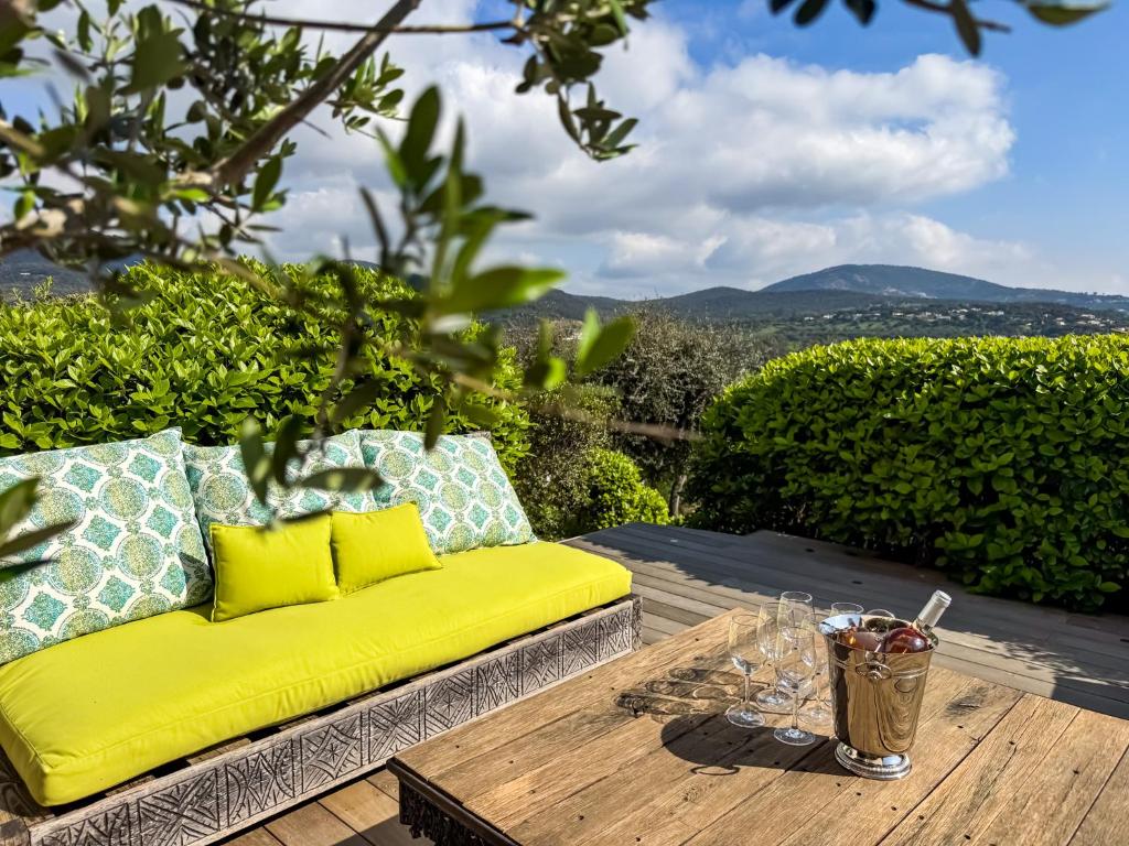 un canapé jaune assis sur une table en bois dans l'établissement Appartement rénové à Grimaud dans le Golfe de Saint-Tropez - Les Restanques, à Grimaud