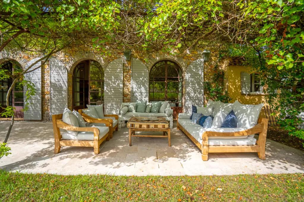 une terrasse avec plusieurs canapés et une table dans l'établissement Villa Vynasa, à Ramatuelle