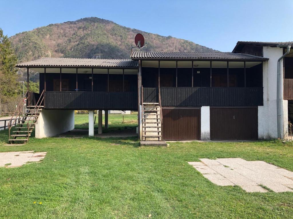 a large building with a hill in the background at Bungalow al Lago in Ledro