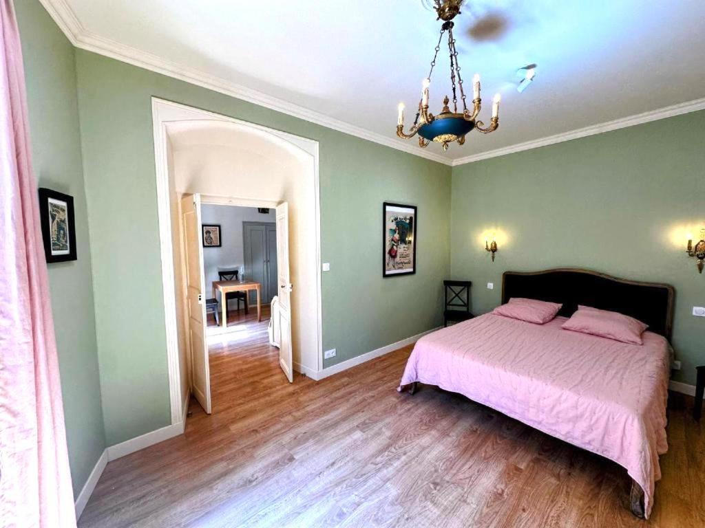 - une chambre verte avec un lit et un lustre dans l'établissement Acquatignese Charme Authentique au Cœur de Bastia, à Bastia