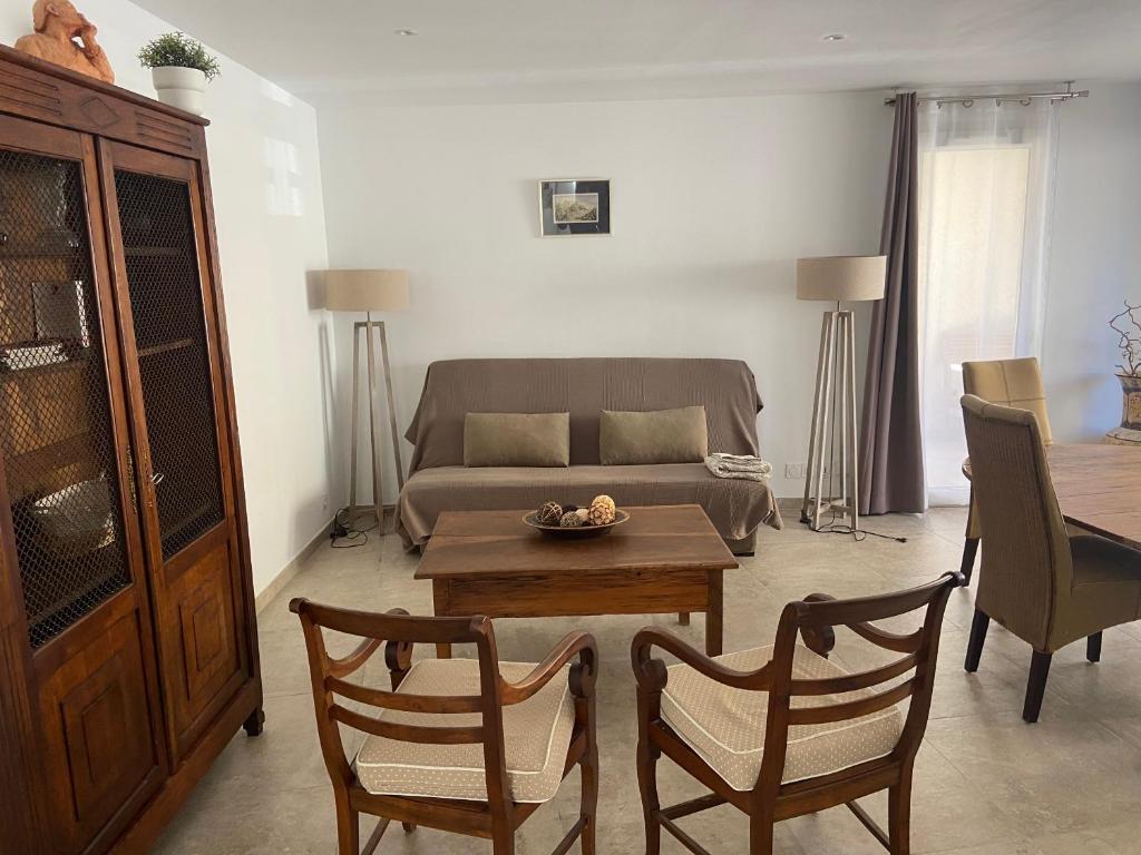 un salon avec un canapé, une table et des chaises dans l'établissement Appartement lumineux, à Calvi