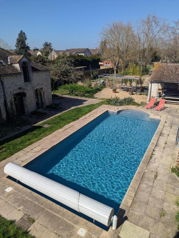 une piscine avec de l'eau bleue dans une cour dans l'établissement Poule Noire Terra Cotta, à Égreville
