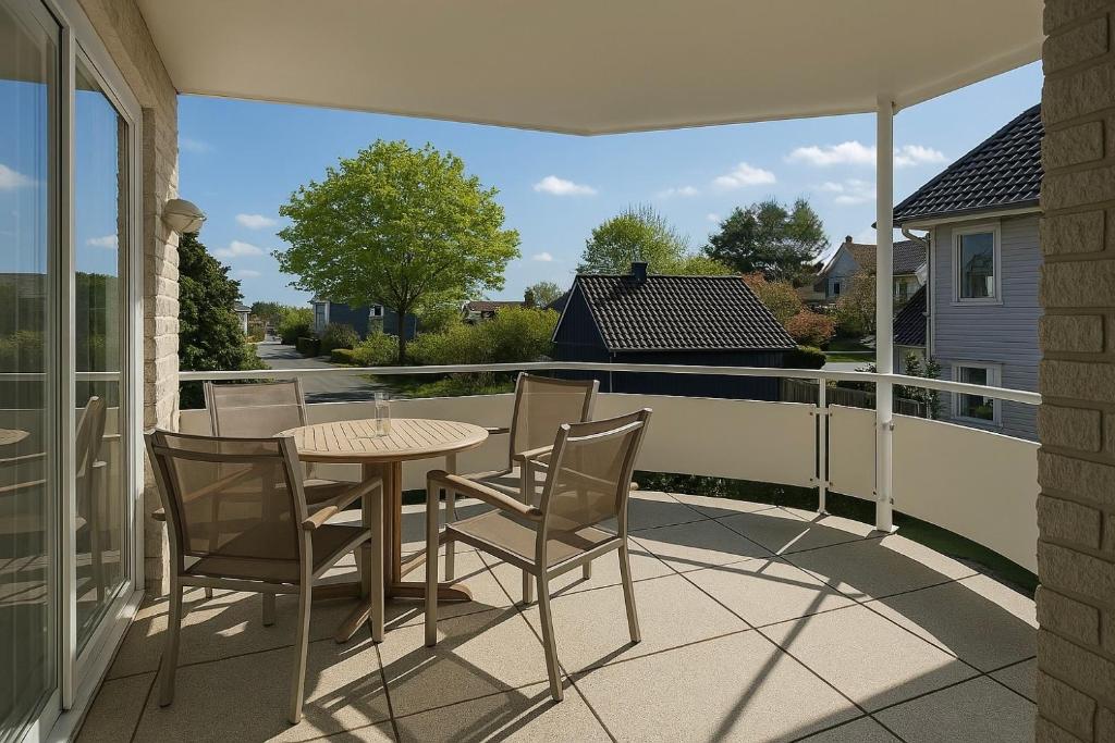een terras met een tafel en stoelen op een balkon bij Ferienwohnung Meeresrauschen in Schausende