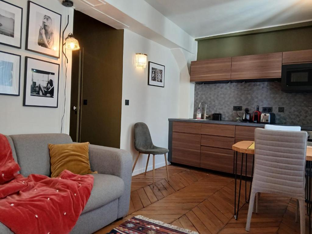 un salon avec un canapé et une cuisine dans l'établissement le velours des gantiers, confort et hospitalité en plein centre historique, à Rouen