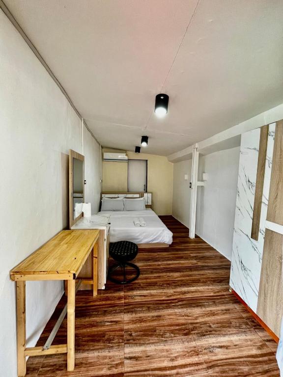 a bedroom with a bed and a desk and a table at Chubbi 5 Room24 in Ban Bang Bamru