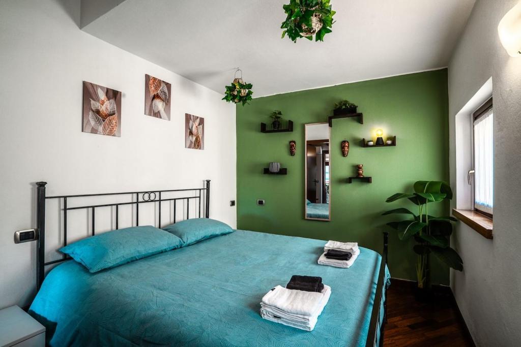 a bedroom with a blue bed with a green wall at Oasi Piacentina in Piacenza
