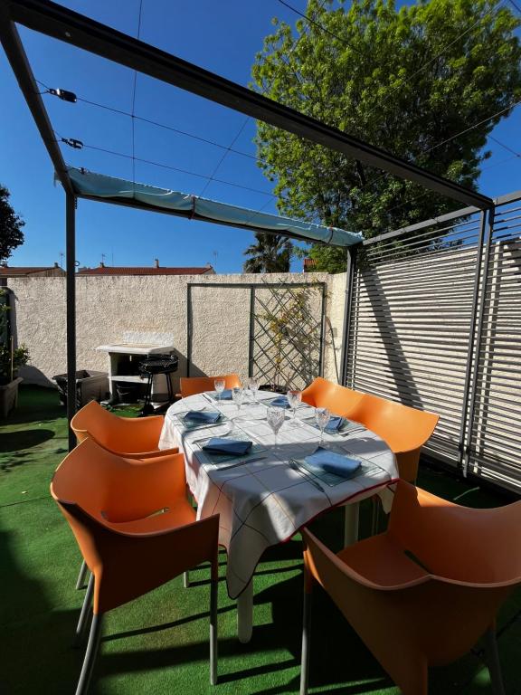 a table and chairs on a patio with a grill at Maison de vacances moderne et pratique : WiFi, clim, parking et cour privée in Canet-en-Roussillon